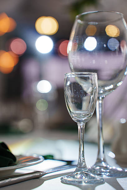 istock Glasses placed on table with blurred lights in background 2251988422