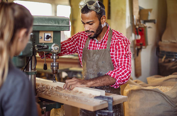 istock Concentrated Artisan in Workshop Using Drill on Wooden Plank 2251988677