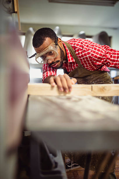 istock Skilled Multiracial Man Sanding Wood with Belt Sander in Workshop 2251988700