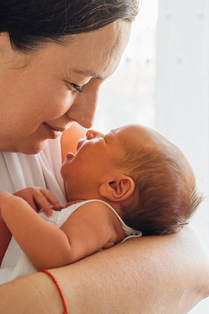 istock Mother holds baby close in bright indoor setting 2251988808