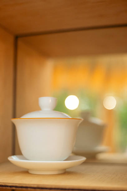 This is an English bone china tea cup. It has an elegant design, with the main body of the cup being light beige in color and featuring delicate stripe patterns. Below the cup rim, there is a gold decorative band, adorned with intricate and exquisite patterns, adding a touch of luxury. The handle is in a graceful curved shape, making it convenient to hold. The bottom features a small high-legged design, which is both delicate and exudes a classic and elegant atmosphere, suitable for pairing with English afternoon tea, fully demonstrating a sense of ceremony.