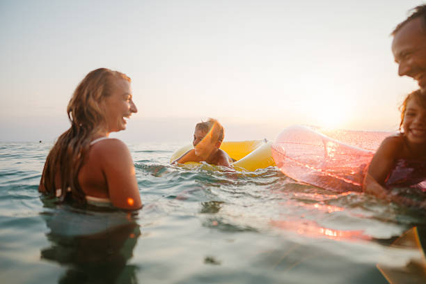 Happy young friends are having fun and runs to swim to sunset sea beach