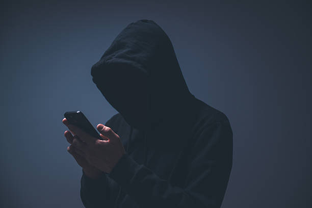istock Silhouetted hacker in a dark hoodie using a smartphone, symbolizing hacking, cyber attacks, and digital intrusion. 2251992331