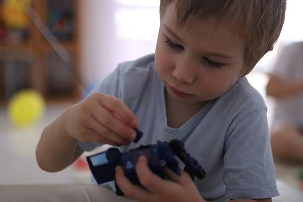 istock Little boy playing with toy robot at home 2251993486
