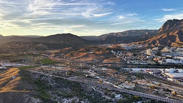 istock Sunset Over Rugged Mountain Slopes And Town, Dramatic Sunset Illuminating Rocky Terrain And Winding Pathways 2251993577