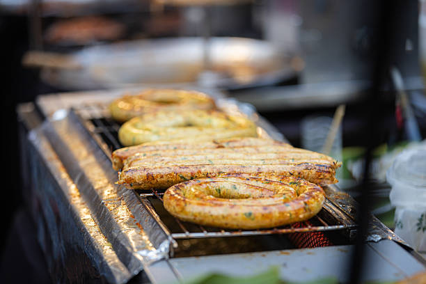 Asian street food market stand.Grilled pork sausages cooking on barbecue at Street food market.Phuket Island - Thailand.