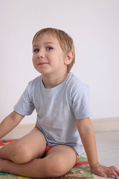 istock Happy child sitting indoors on colorful blanket 2251996777