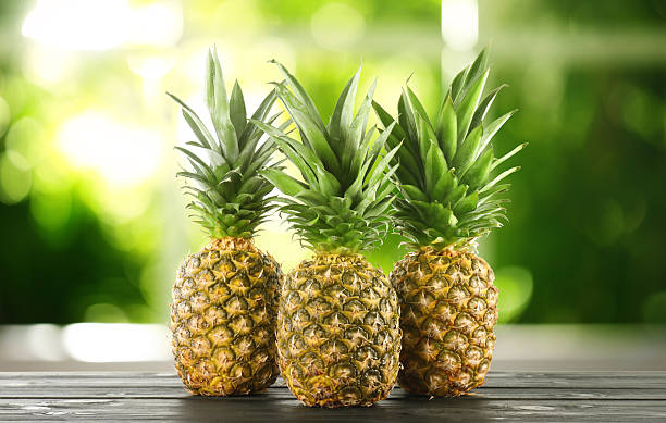istock Fresh ripe pineapples on wooden table indoors 2251997923