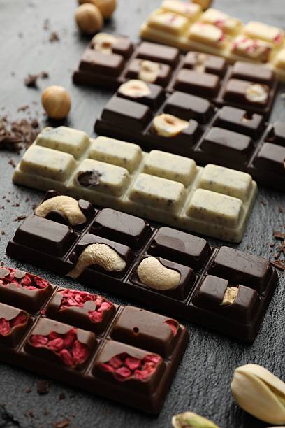 istock Different tasty chocolate bars with nuts and freeze dried raspberry on black table, closeup 2251998231