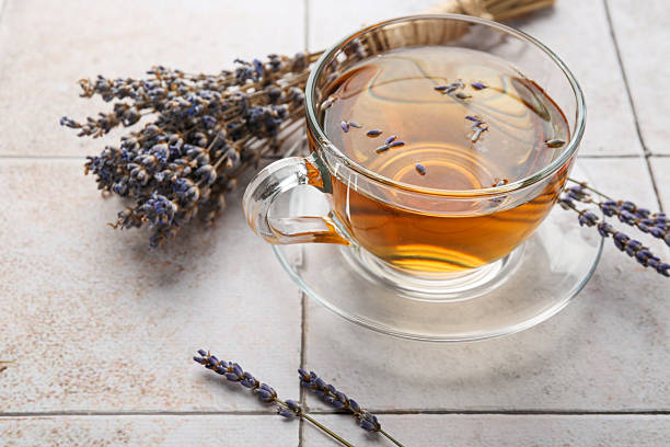 istock Aromatic lavender tea in glass cup and dry flowers on white tiled table, closeup 2252000860