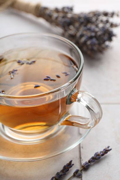 istock Aromatic lavender tea in glass cup and dry flowers on white tiled table, closeup 2252000884