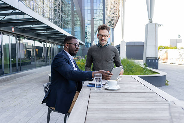 istock Two men are having a business meeting outdoors using a laptop 2252001647