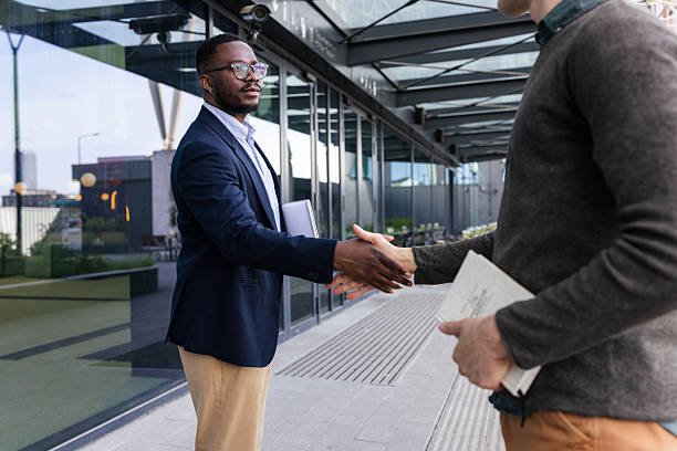 istock Businessmen shaking hands outside an office building 2252001694