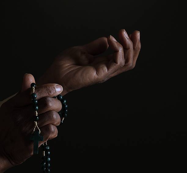 istock praying to God with hands together with cross 2252001714