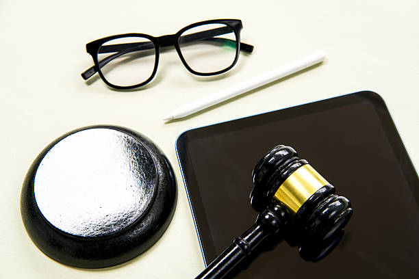istock Judge's gavel, digital tablet, pen and glasses on a light green background. 2252003131