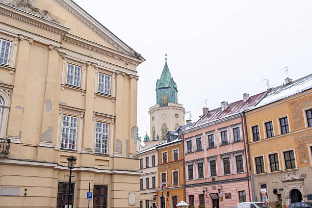 Former Town Hall is the central point of Lublin's Market Square, Poland. It served as the Crown Tribunal. A yellow building stands on city square. Trinitarian Tower in Lublin is on the background