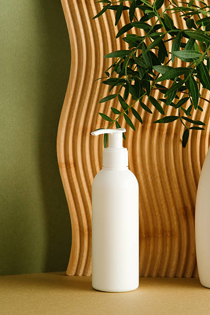 istock White shampoo pump bottle mockup with wooden panel and green leaves on background. 2252012153