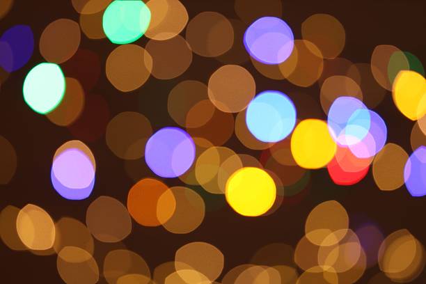 Blurred out-of-focus bright lights of a garland on a dark background close-up selective focus