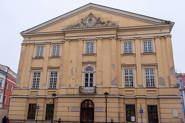 istock Old building with yellow paint and large windows in city square 2252012732