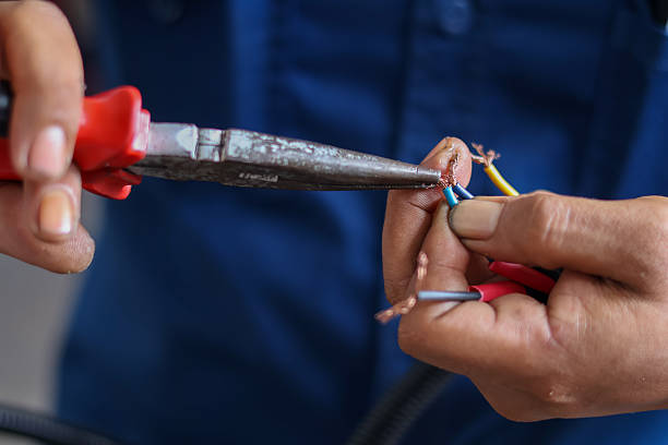 istock Close-up of a hand using pliers to twist or secure stripped copper electrical wires 2252013126