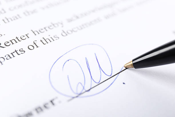 Pen leaving signature on contract, closeup view