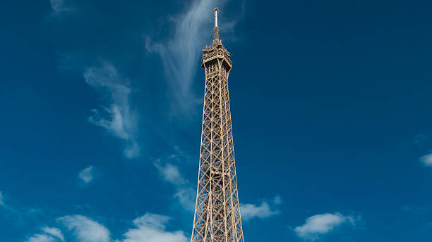 Top of the Eiffel tower timelapse from waterfront at the river Seine in Paris. Viewpoint with tourists on observation deck at sunny summer day