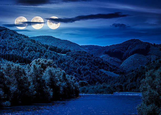 istock river flows through green forest near mountain at night 2252016218
