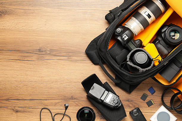 istock Professional photographer's equipment and backpack on wooden background, flat lay. Space for text 2252017113