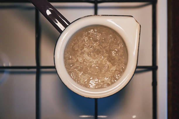 A coffee pot with water is boiled on a stove with a flame