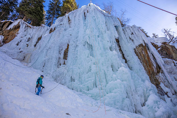 Imst Pitztal, Austria - 02 February 2024: Ice climbers ascending frozen waterfall with technical tools and ropes vertical ice wall winter mountaineering sport extreme outdoor activity in alpine environment