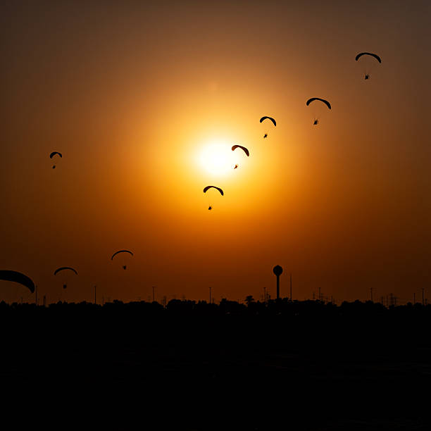 Paramotor pilots performing aerobatics in formation.