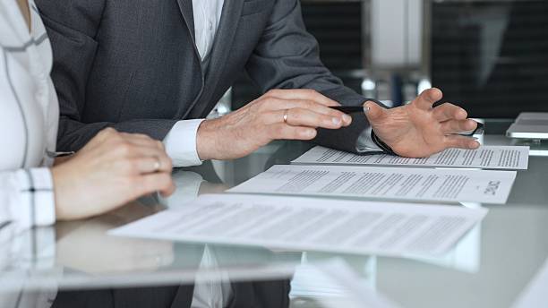 istock Business executive hands gesturing over contract on glass table during formal office meeting negotiating legal agreement terms. Business people concept 2252024046