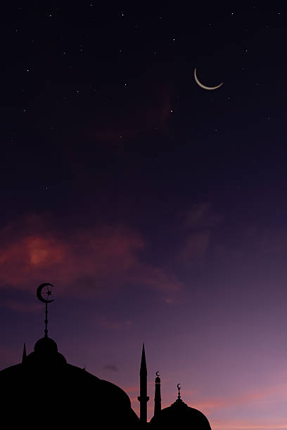 Ramadan mosque silhouette at night with crescent moon in the sky.Vertical image Islamic festival background for Eid Mubarak,Ramadan Kareem, Muharram, Adha, and religious New Year greeting.