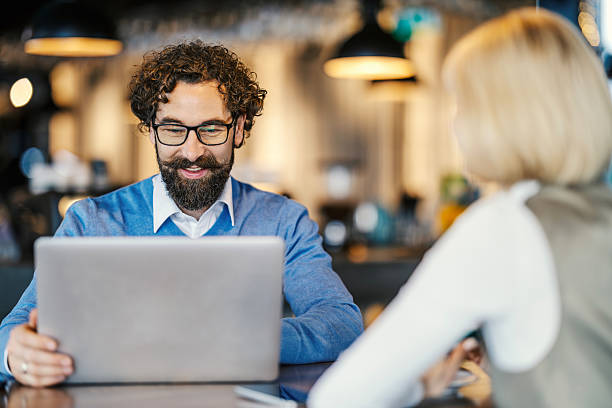 istock Smiling man working on laptop during business meeting 2252028312