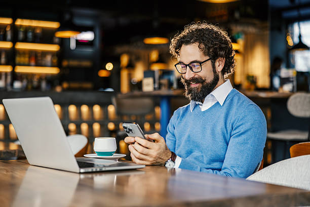 istock Mid adult man happily working remotely in cafe 2252028500