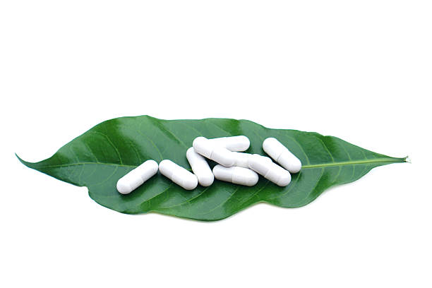 istock White herbal capsules on a fresh green leaf isolated on white background, representing natural medicine, organic supplements, alternative healthcare, wellness, and eco-friendly pharmaceutical concept. 2252031497