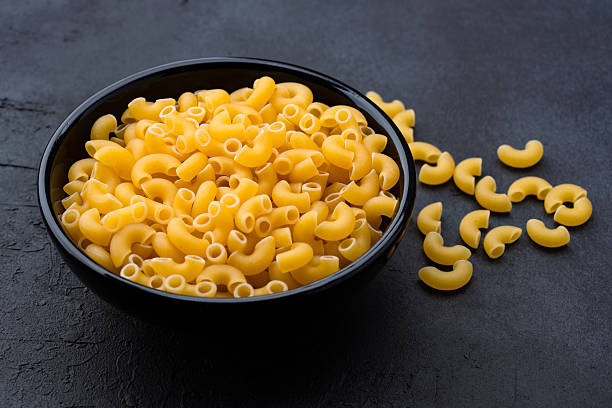 istock Raw macaroni pasta on black stone background 2252032307