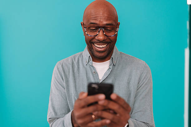 istock Man Smiling While Looking at His Phone Happily 2252032328