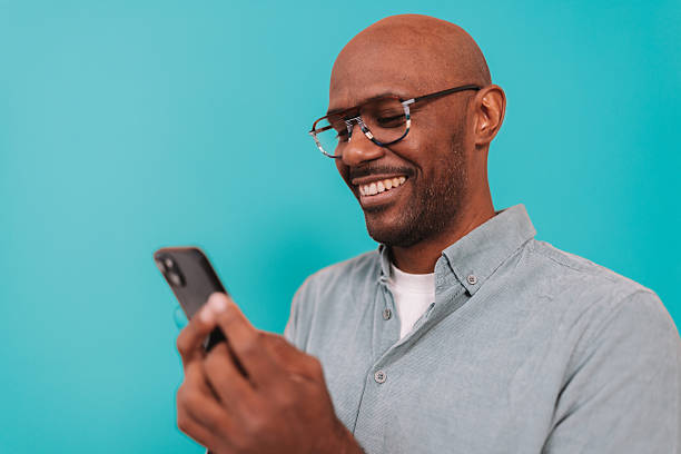 istock Happy man smiling at phone with satisfaction 2252032496