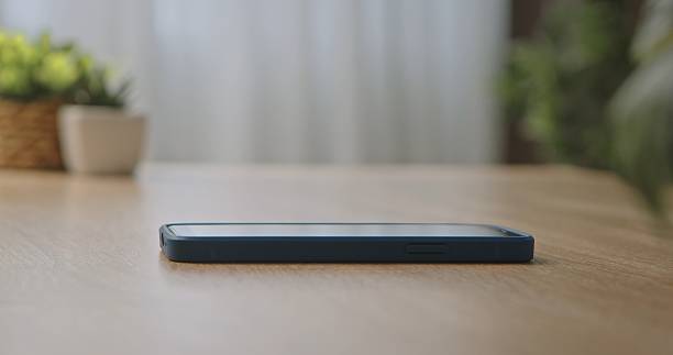 istock Smartphone with Blue Case on Wooden Table in Soft Light 2252036382