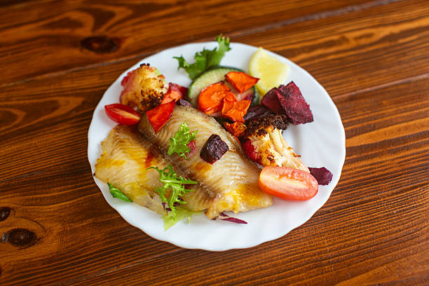 Nutritious seafood dinner with roasted vegetables and herbs.