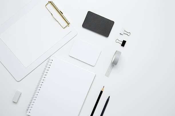 istock Monochrome stationery items. On a white background, an empty mock up notebook and clipboard, white and black cards 2252042738