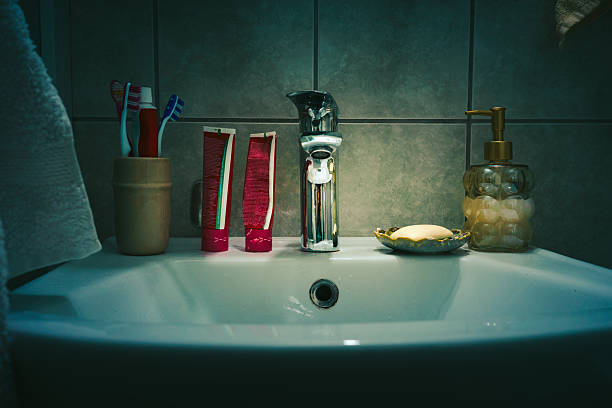 Man applying toothpaste on brush in the bathroom