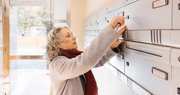 istock Senior woman opening apartment mailbox with key 2252048600
