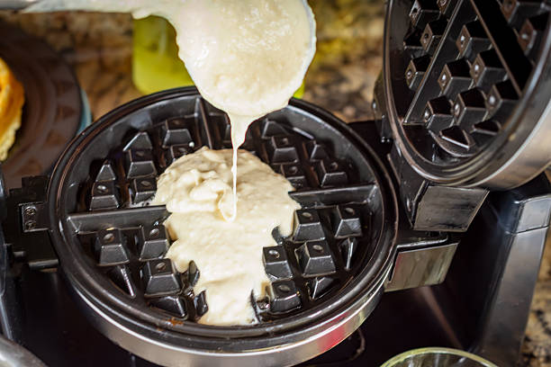 istock Thick, smooth waffle batter is scooped and poured onto the hot, pre-greased waffle iron, ready to cook a crispy breakfast in Waukesha County. 2252051813
