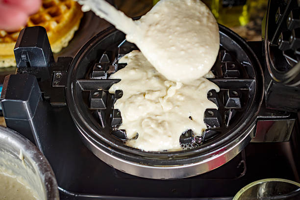 istock Thick, smooth waffle batter is scooped and poured onto the hot, pre-greased waffle iron, ready to cook a crispy breakfast in Waukesha County. 2252051865
