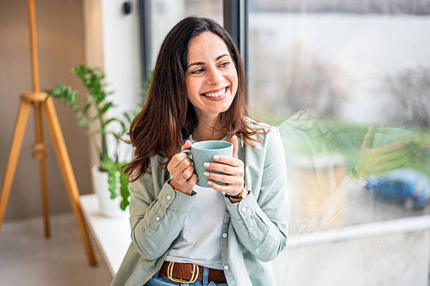 istock Woman enjoying morning coffee looking out window 2252051896
