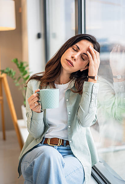 istock Woman holding coffee suffering from headache and stress 2252052516