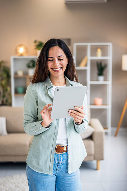 istock Woman smiling using tablet at home 2252052731
