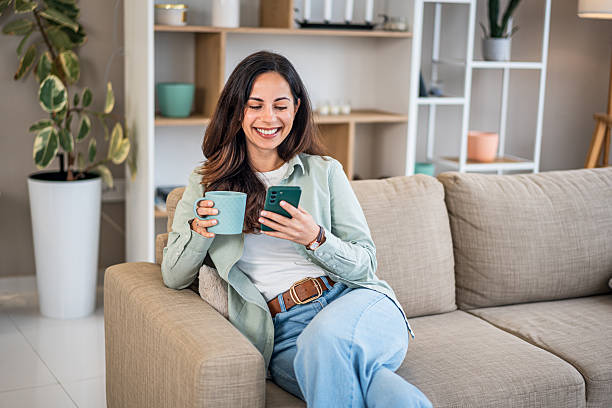 istock Young woman relaxing on sofa using mobile phone 2252053096